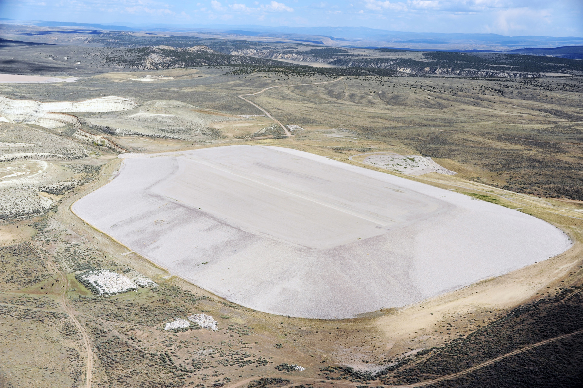 Aerial image of one of the two Maybell disposal sites showing an irregular, gravel-covered polygon in an arid, mountainous landscape