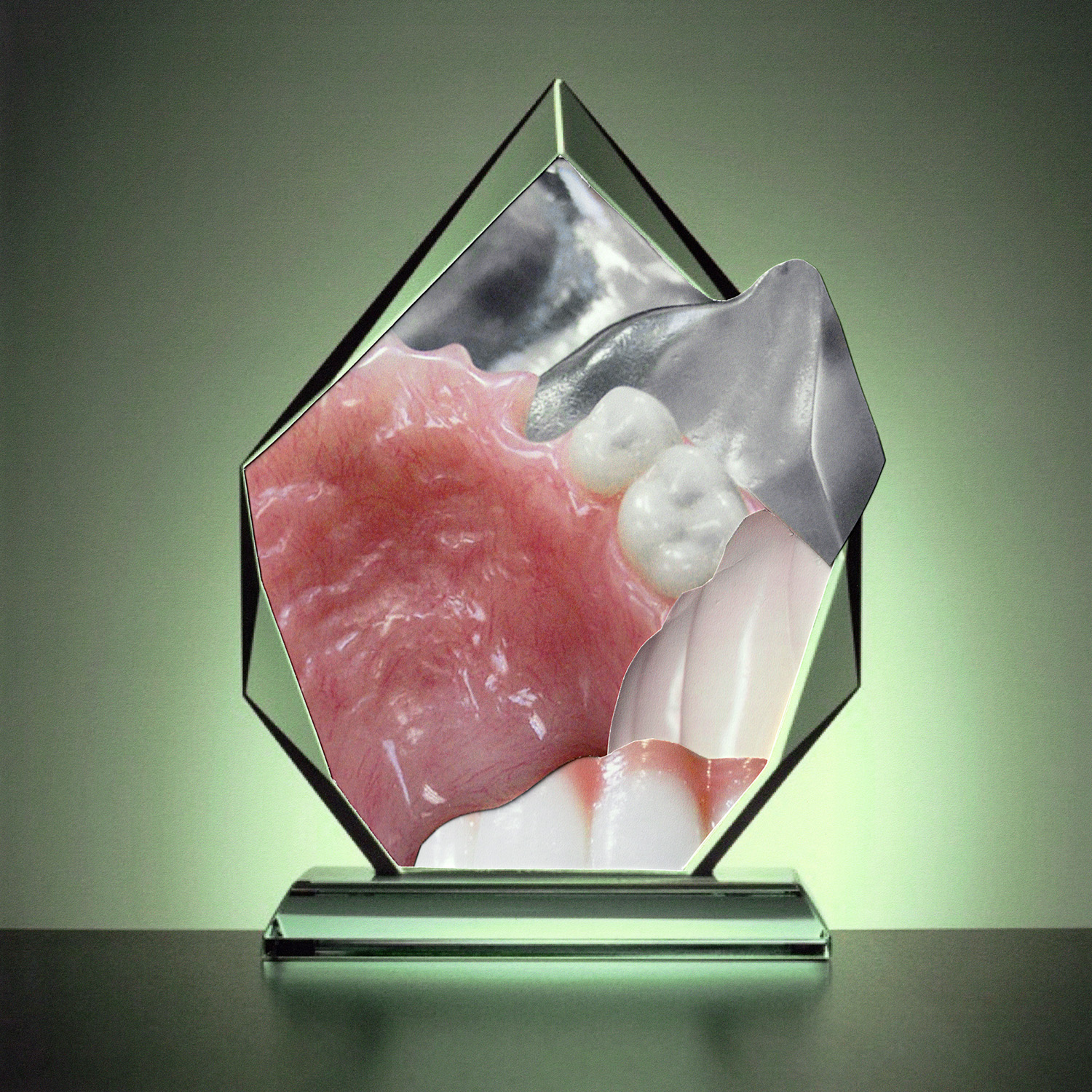 Color photographic collage showing a green-tinged glass paperweight containing collaged images of human teeth and gums.