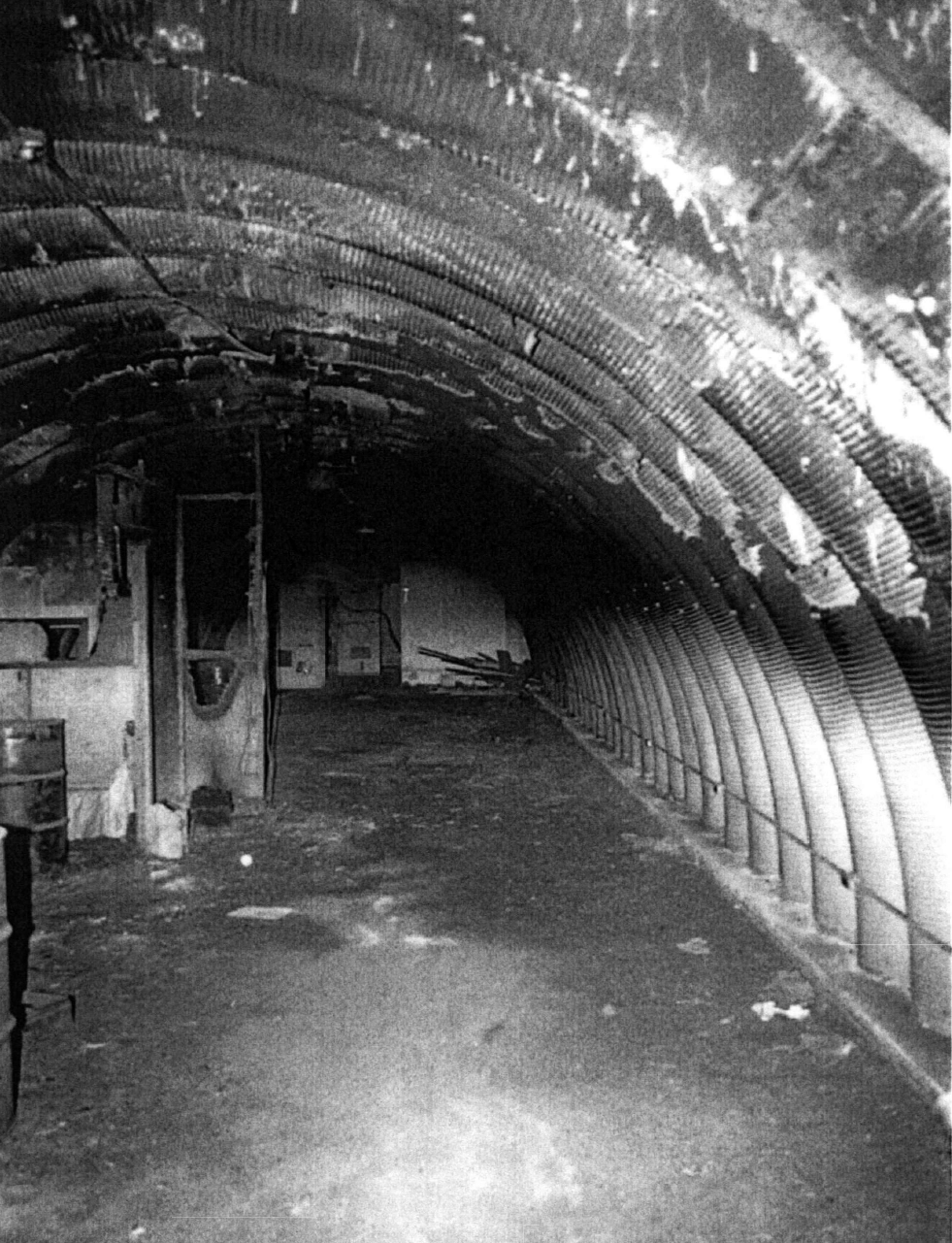 Black and white image showing ruined interior of a buried quonset hut
